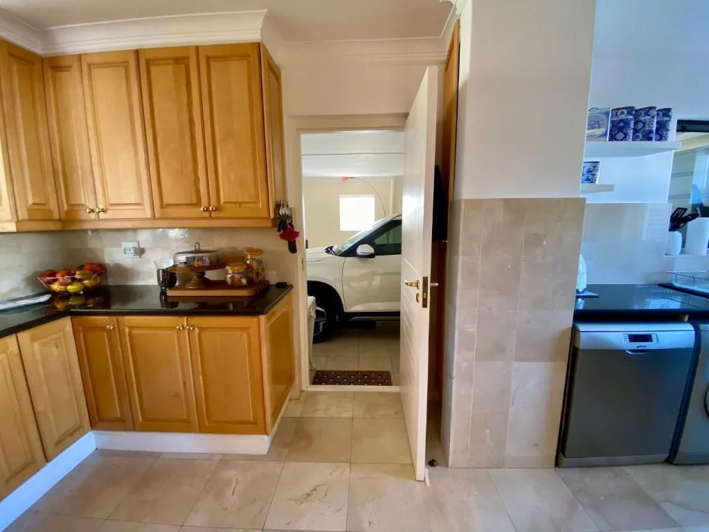 Spacious kitchen with wooden cabinetry, black countertops, and stainless steel appliances