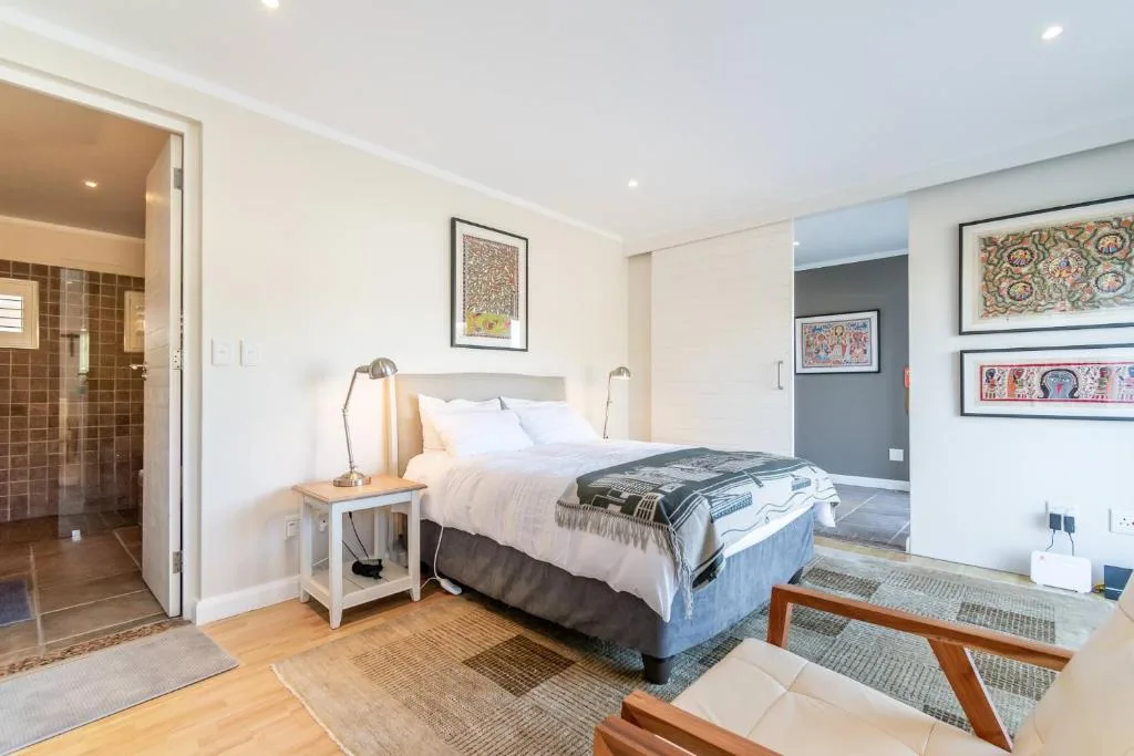 Bright bedroom with queen bed, ensuite bathroom, and modern decor