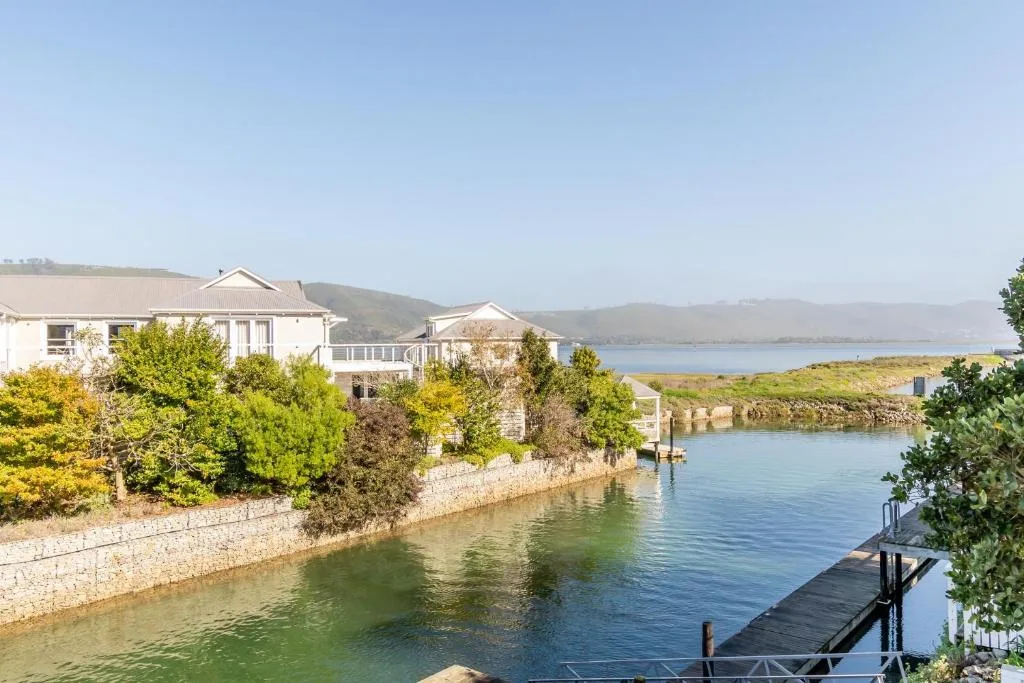 Waterfront property with lagoon views and distant mountains under clear skies