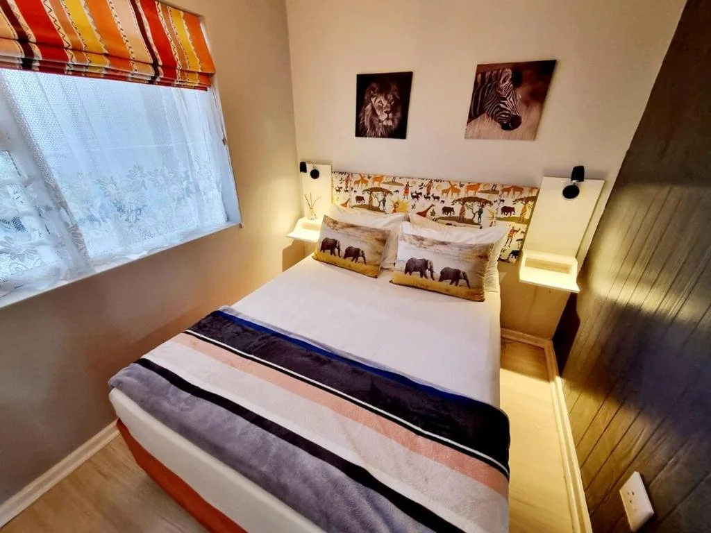 Cozy bedroom with double bed, wildlife artwork, and warm lighting