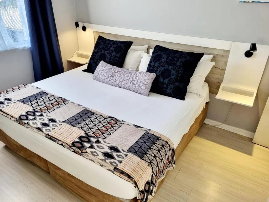 Modern bedroom with queen bed, black patterned pillows, and contemporary nightstands