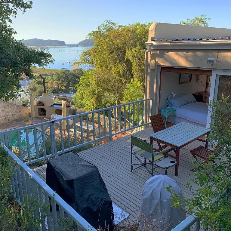 Wooden deck with outdoor seating overlooking Knysna lagoon and mountains