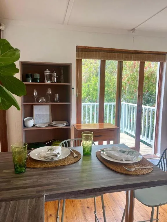 Dining table set for two with place settings and green glassware