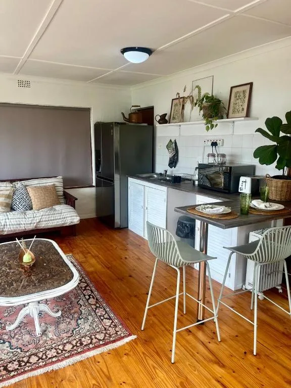 Open-plan lounge with kitchen, wooden floors, modern furnishings