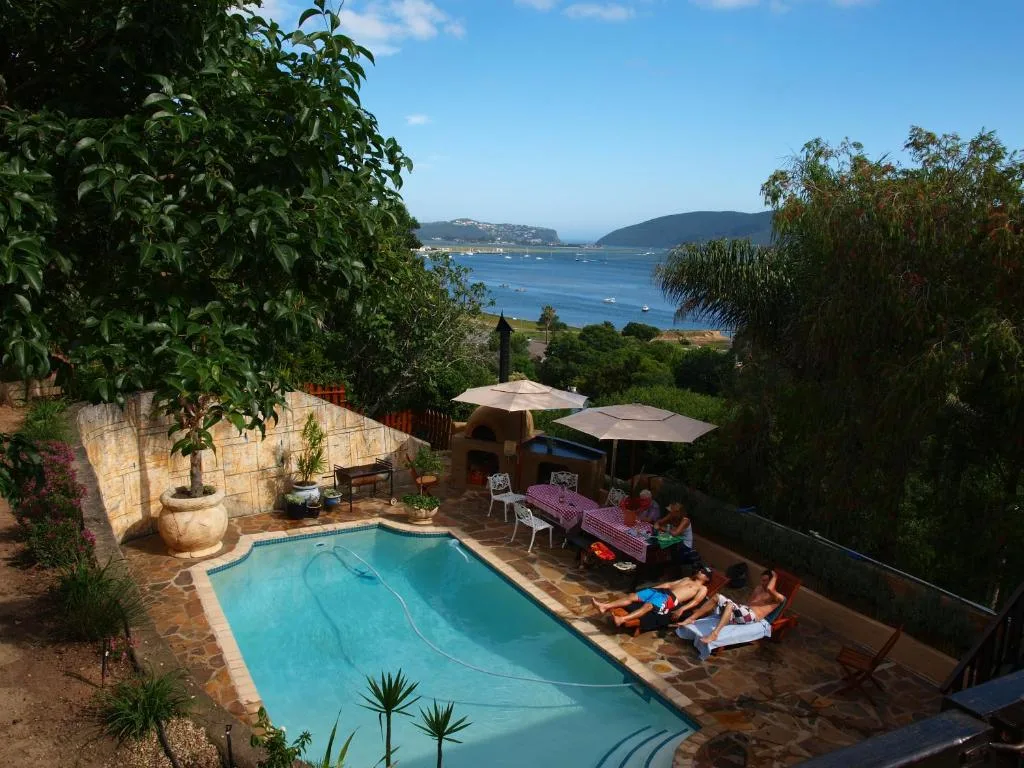 Swimming pool with ocean and mountain views in background