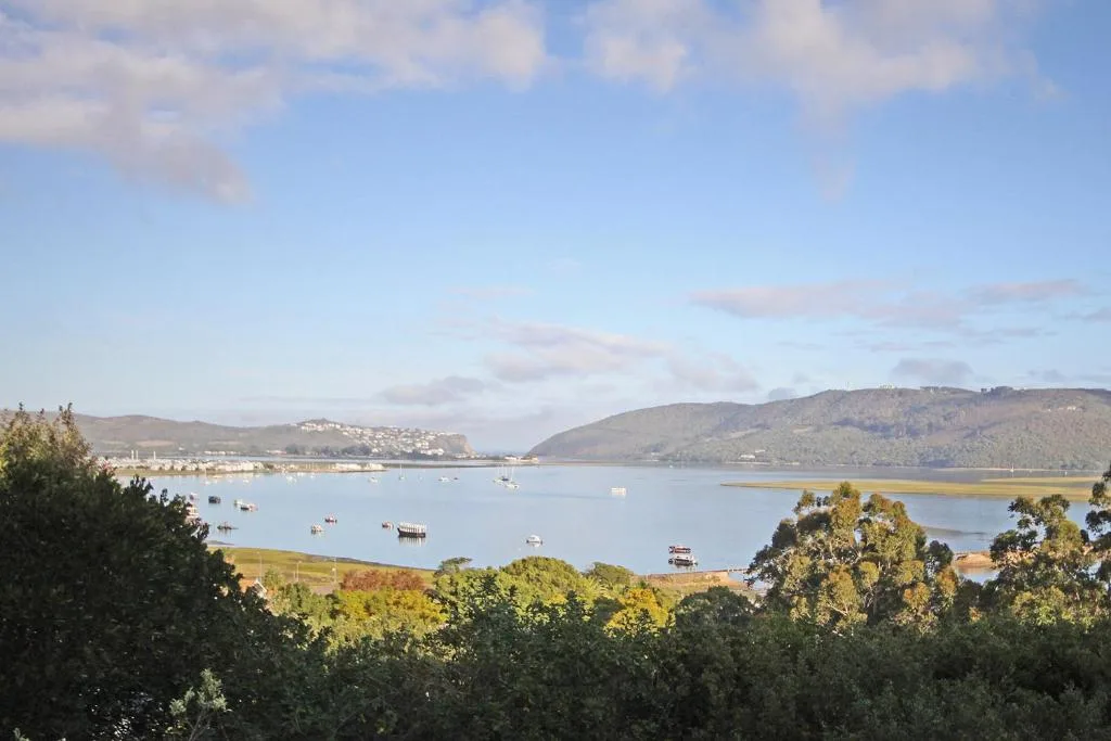 Scenic lagoon view with moored boats and forested hills