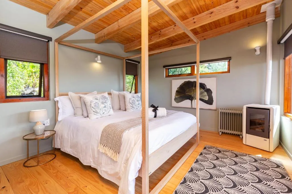 Modern bedroom with wooden four-poster bed and exposed beam ceiling