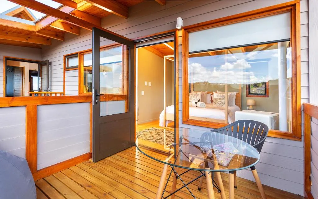 Wooden deck with seating area and glass doors overlooking bedroom