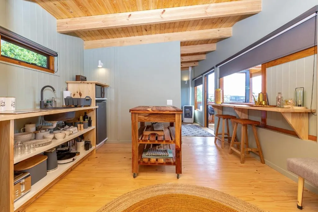 Modern kitchen with wooden beams, open shelving, and natural light