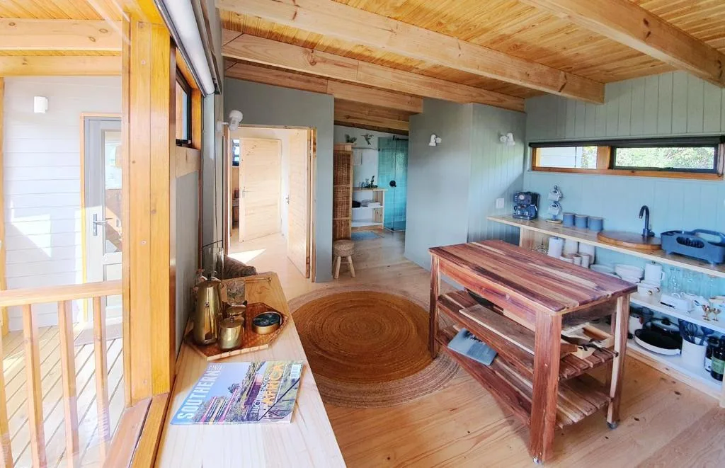 Open-plan kitchen with wooden counter, sink, and storage in studio apartment