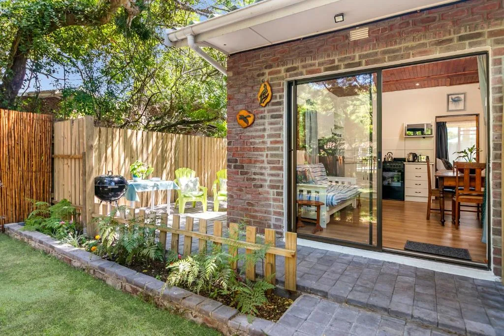 Brick exterior with patio area, garden seating, and large sliding glass doors