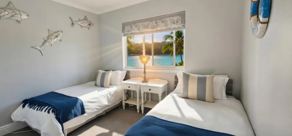 Bright twin bedroom with ocean view and coastal decor accents