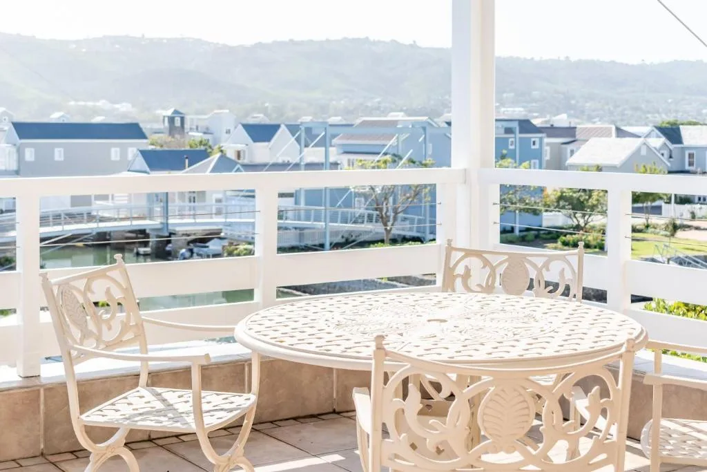 Waterfront deck with round table, chairs overlooking lagoon and town