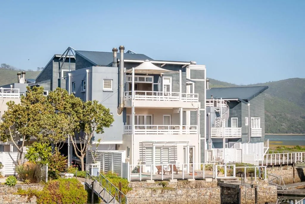 Modern waterfront apartment building with multiple decks overlooking Knysna lagoon