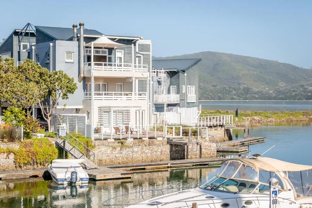 Waterfront property with white architecture overlooking lagoon and mountains