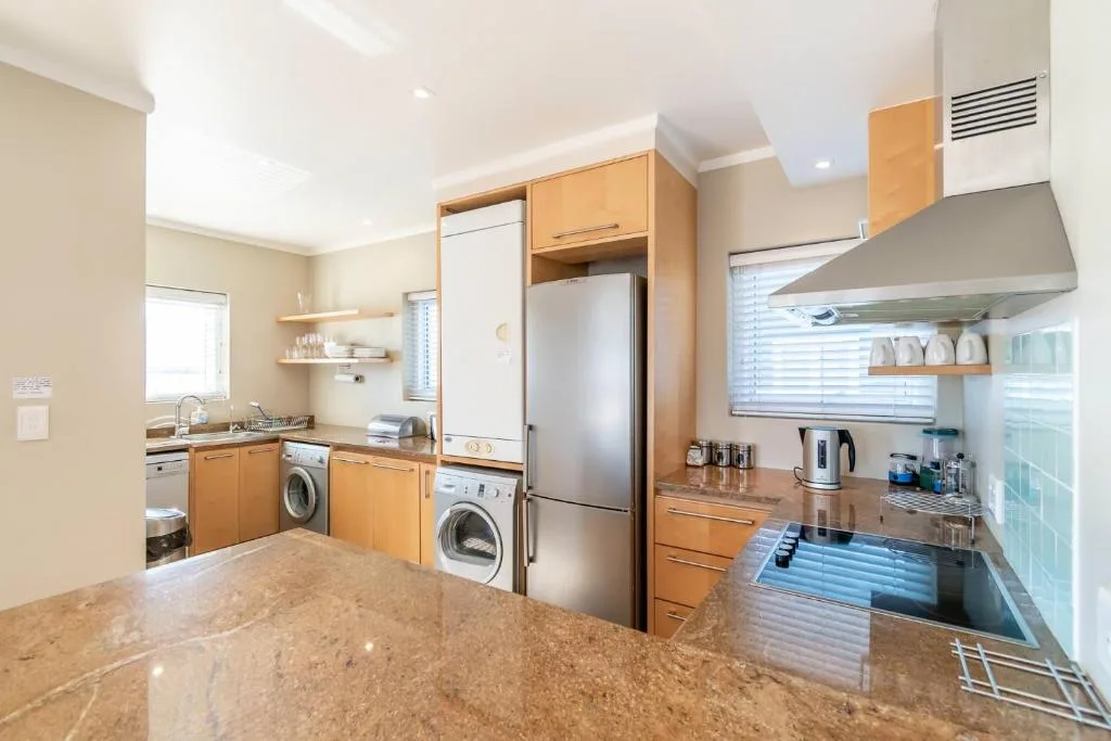Modern kitchen with wooden cabinetry, stainless steel appliances, granite countertop