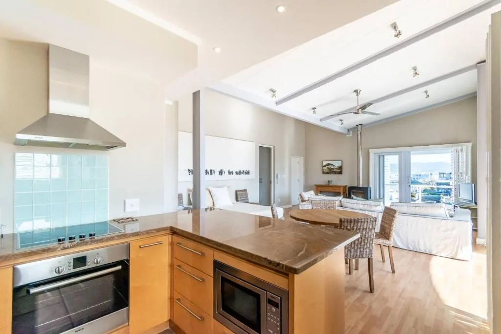 Modern kitchen with wooden cabinetry, stainless steel appliances, and island counter