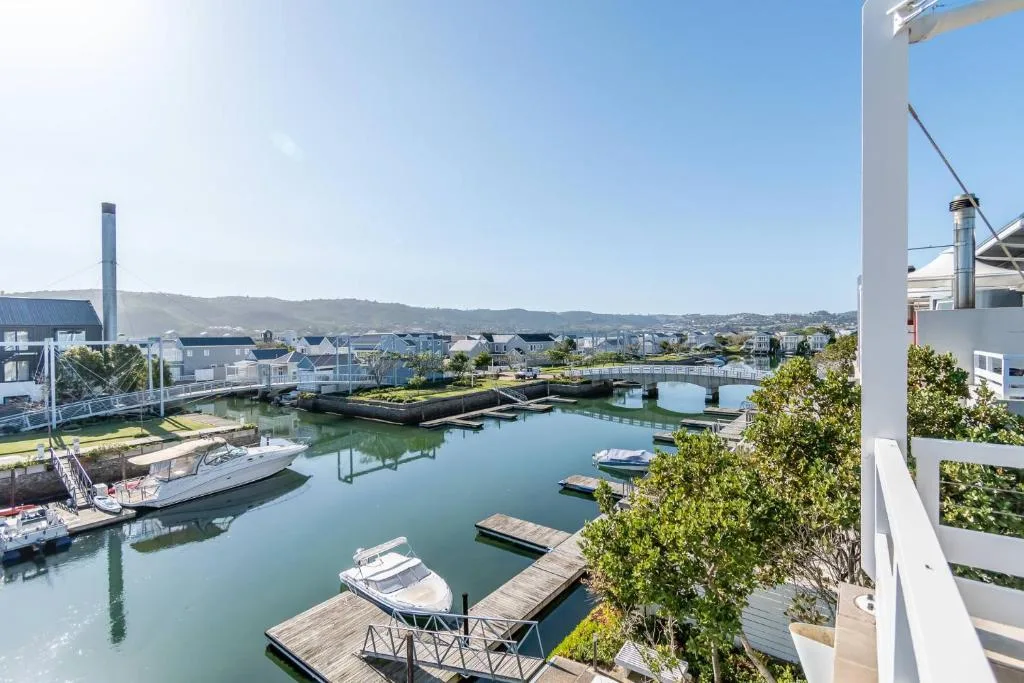 Scenic waterfront view of Knysna lagoon with moored boats and distant hills