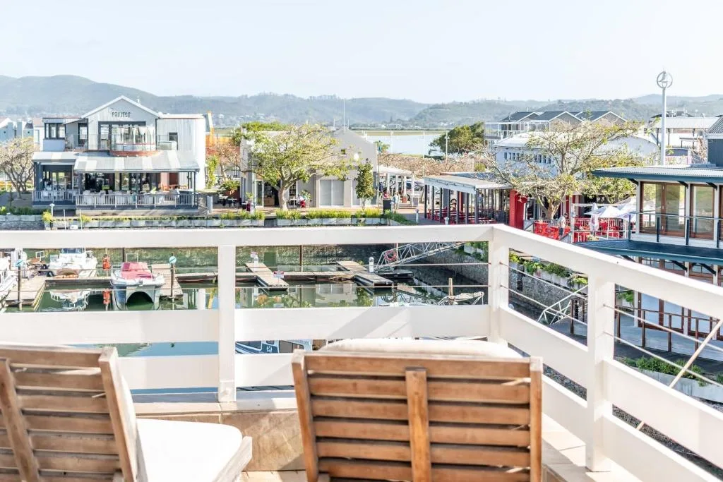 Waterfront village view with mountains, lagoon, and leisure boats from deck