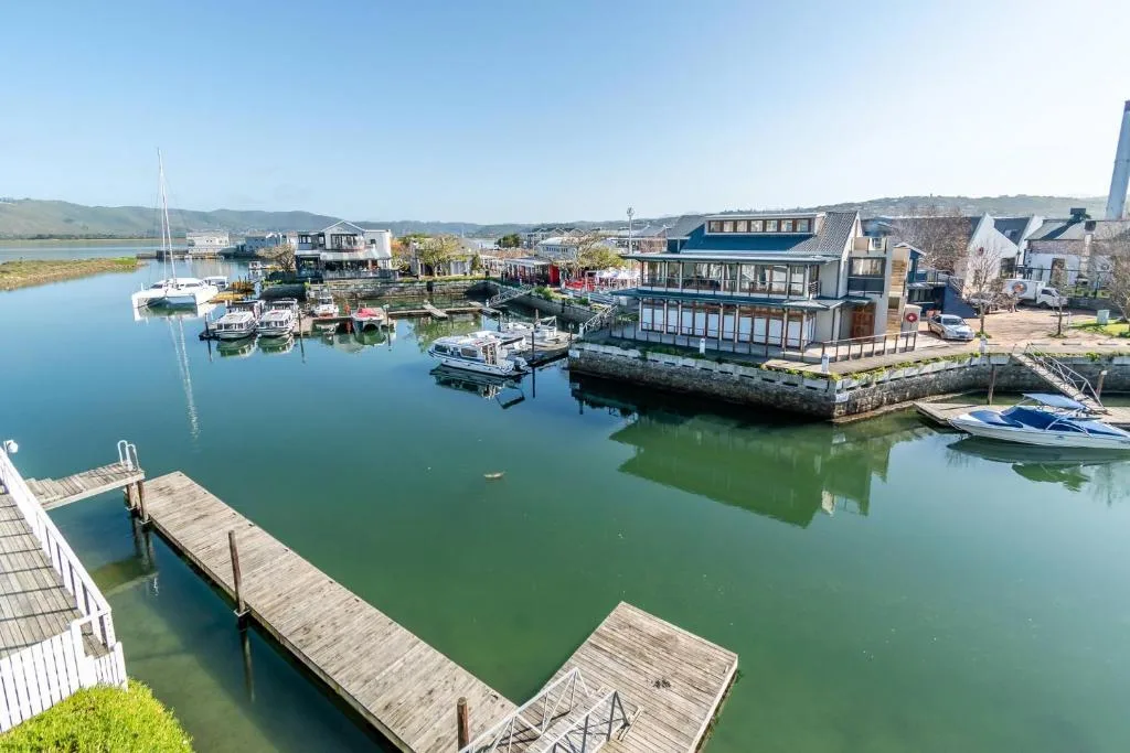 Scenic lagoon view with boats, docks, and waterfront buildings on horizon