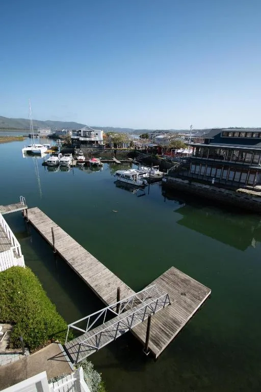 Scenic waterfront view of Knysna harbour with boats and mountains beyond