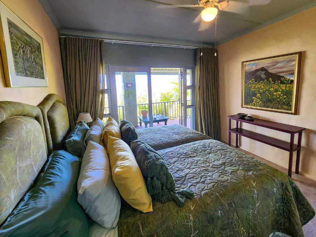 Spacious bedroom with dual beds, deck access, and mountain artwork
