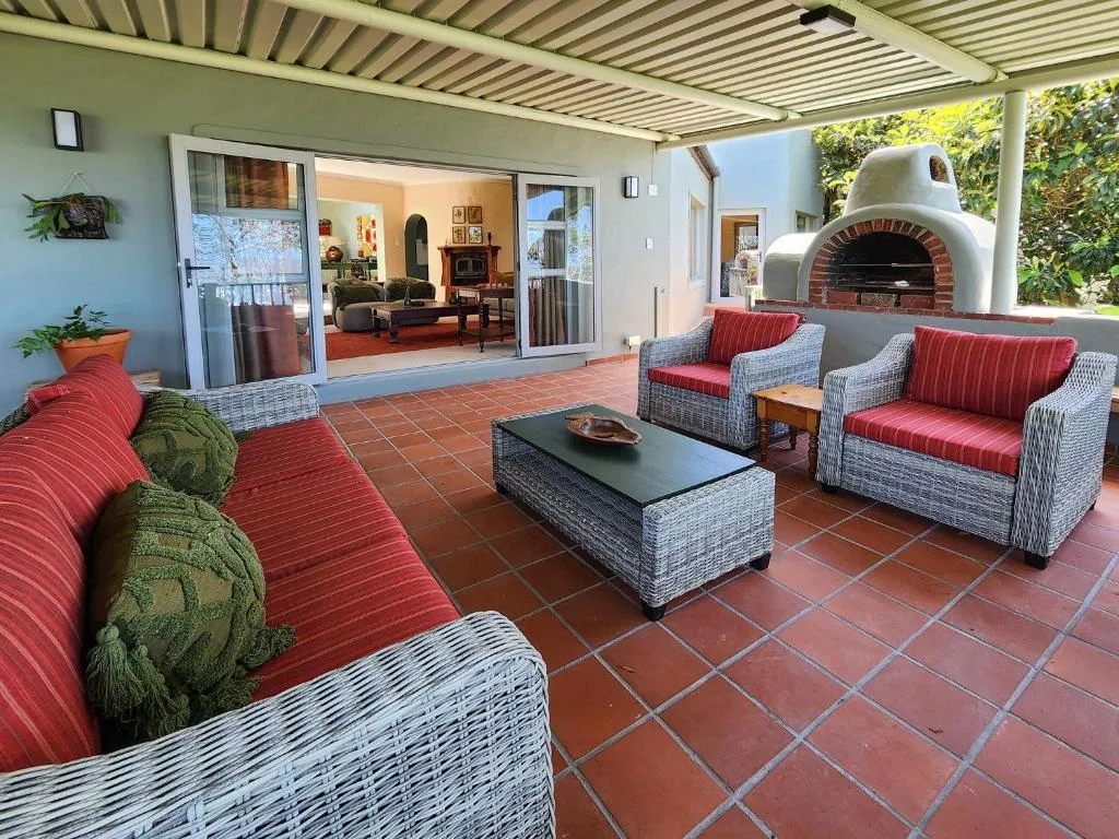 Covered patio with rattan seating, fireplace, and indoor access doors