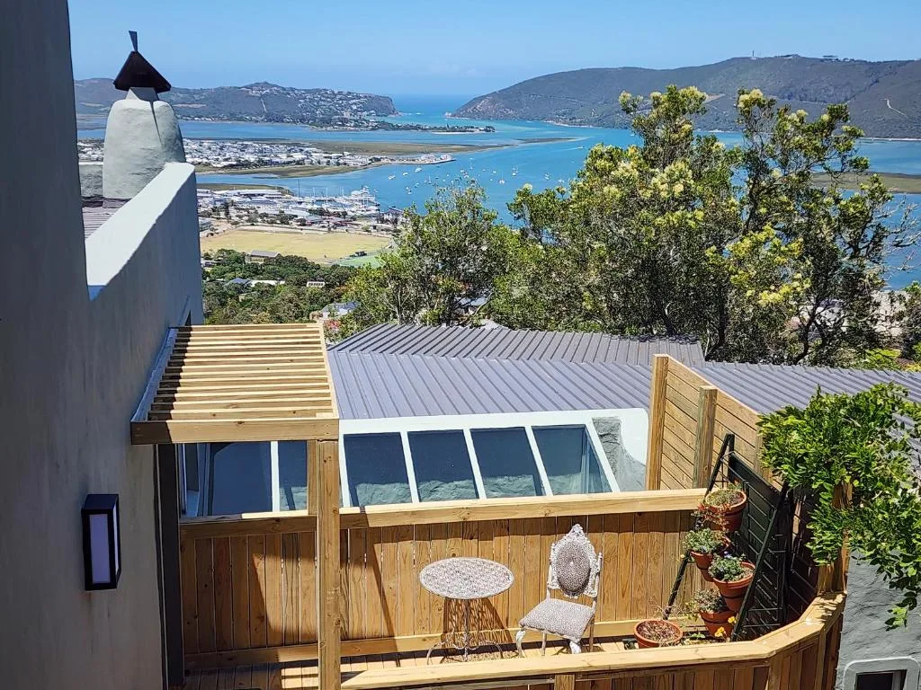 Wooden deck with seating overlooking lagoon and coastal mountains