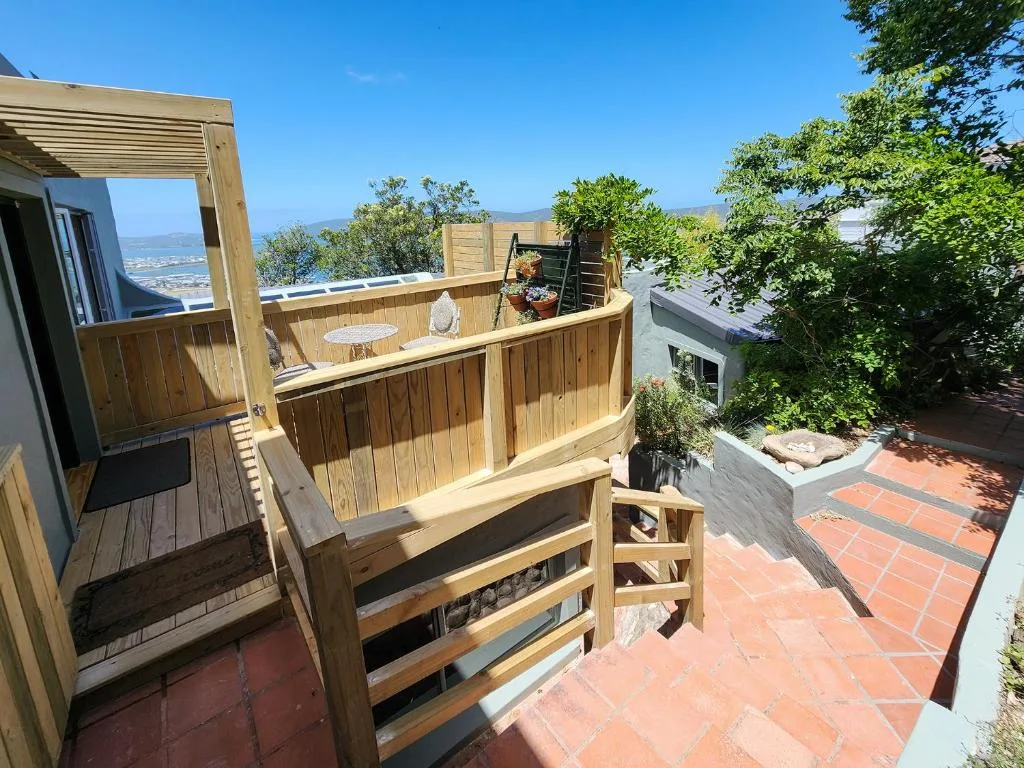 Wooden deck with ocean view, pergola, and outdoor seating area