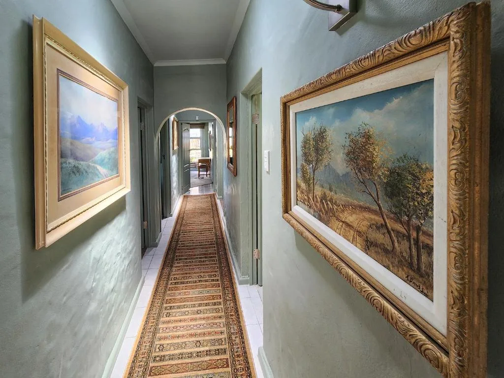 Elegant hallway with framed landscape artworks and decorative runner