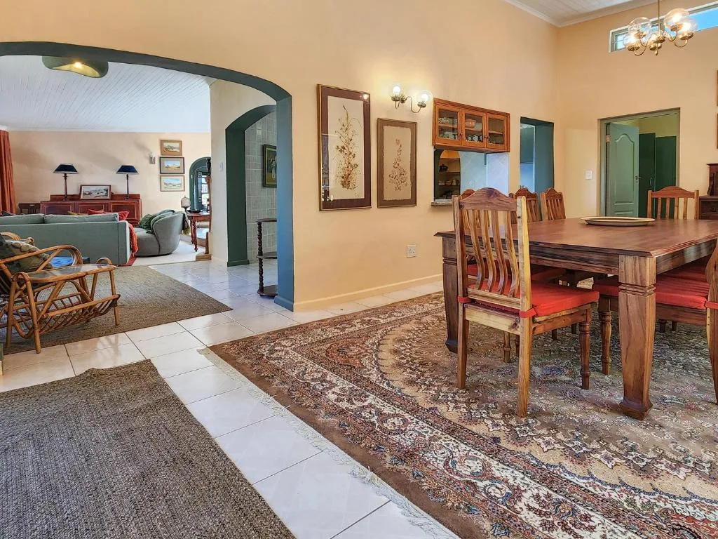 Spacious dining area with wooden table and chairs in warm interior