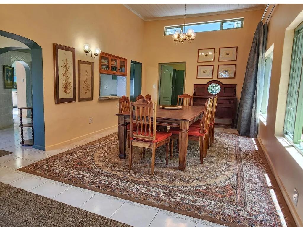 Warm dining room with wooden table, chairs, and framed botanical artwork