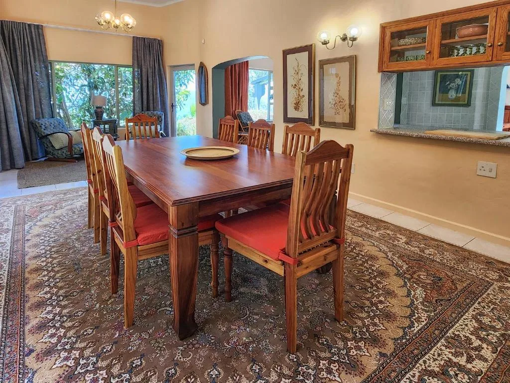 Spacious dining room with wooden table and red cushioned chairs
