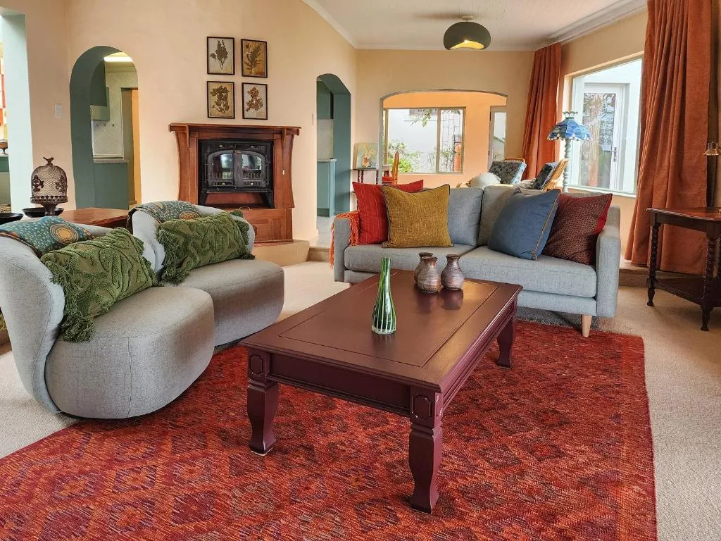 Spacious living room with curved sofas, wooden coffee table, and fireplace