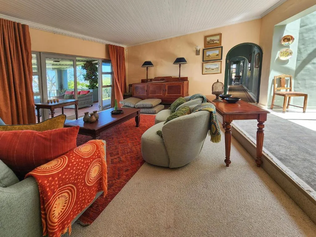 Spacious lounge with comfortable seating, wooden furniture, and ocean views through glass doors