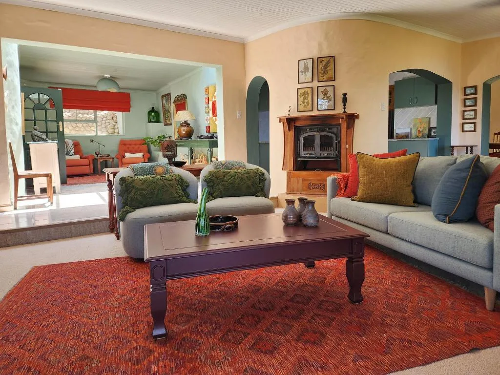 Spacious lounge with sofas, fireplace, and colorful cushions throughout