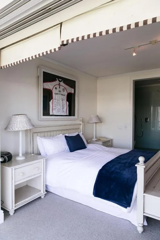 Bright bedroom with white bed, navy accents, and coastal decor