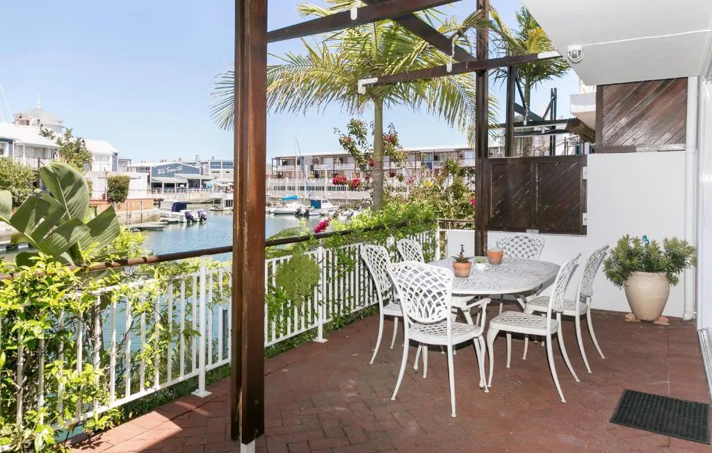 Waterfront deck with dining table, chairs, and lagoon views
