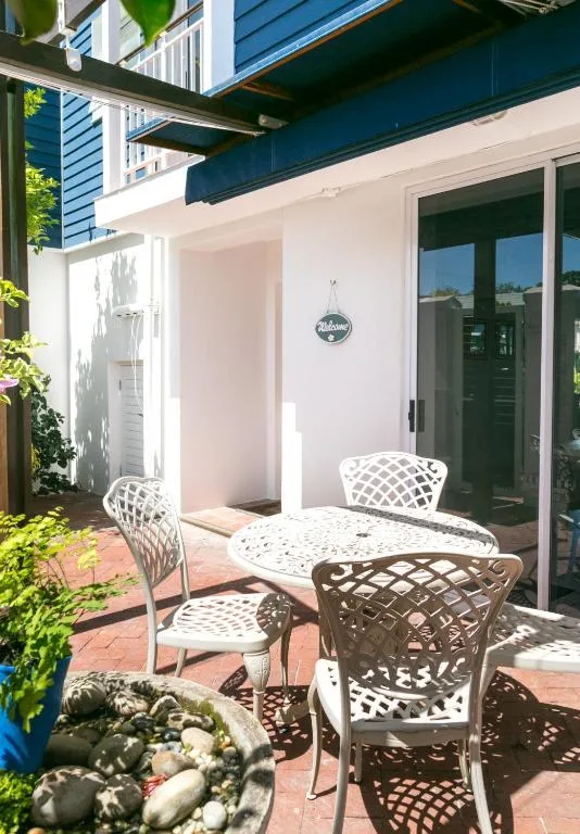 Outdoor patio with white lattice chairs and round table