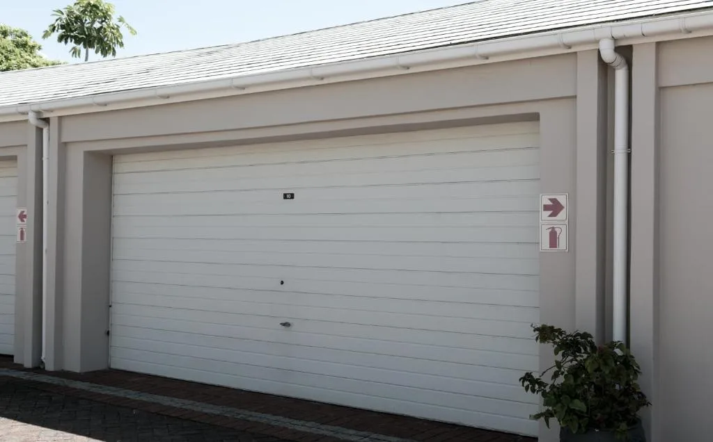 Modern white garage doors on contemporary coastal residential building facade