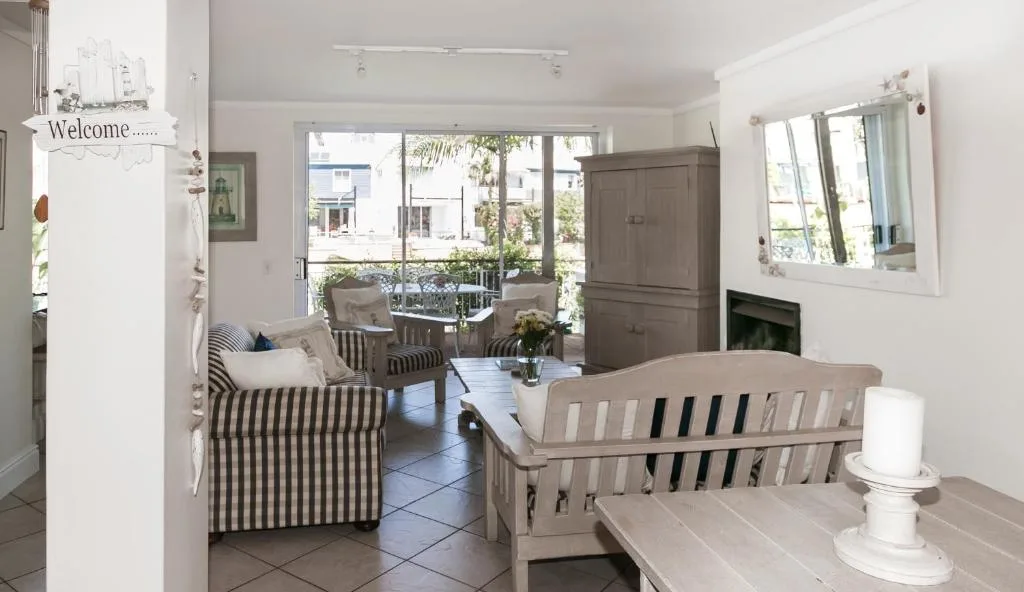 Bright lounge with striped armchairs, fireplace, and deck views