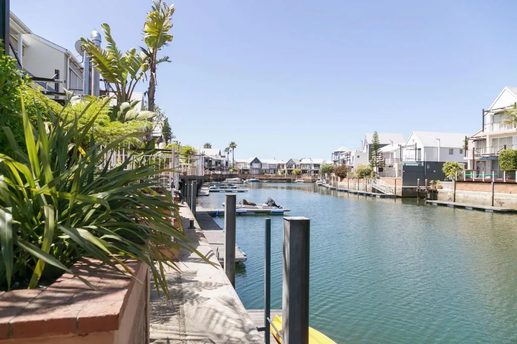 Scenic waterfront canal with moored boats and colorful houses