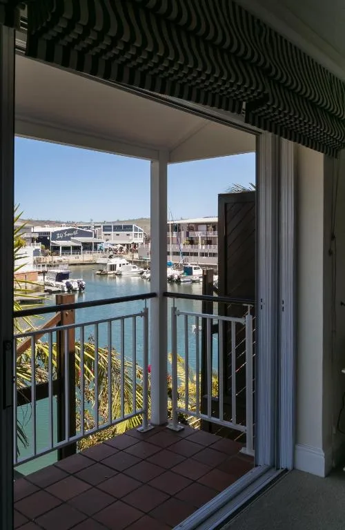 Waterfront balcony overlooking Knysna Quays marina with boats and buildings