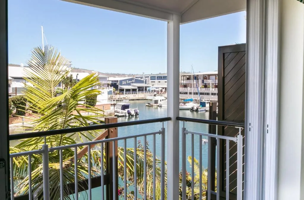 Waterfront view of Knysna lagoon and marina from covered balcony with railings