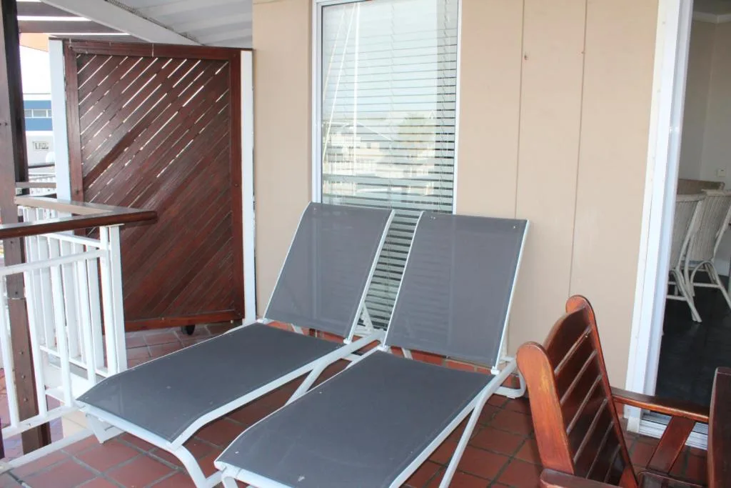 Outdoor deck with loungers and sea view through windows