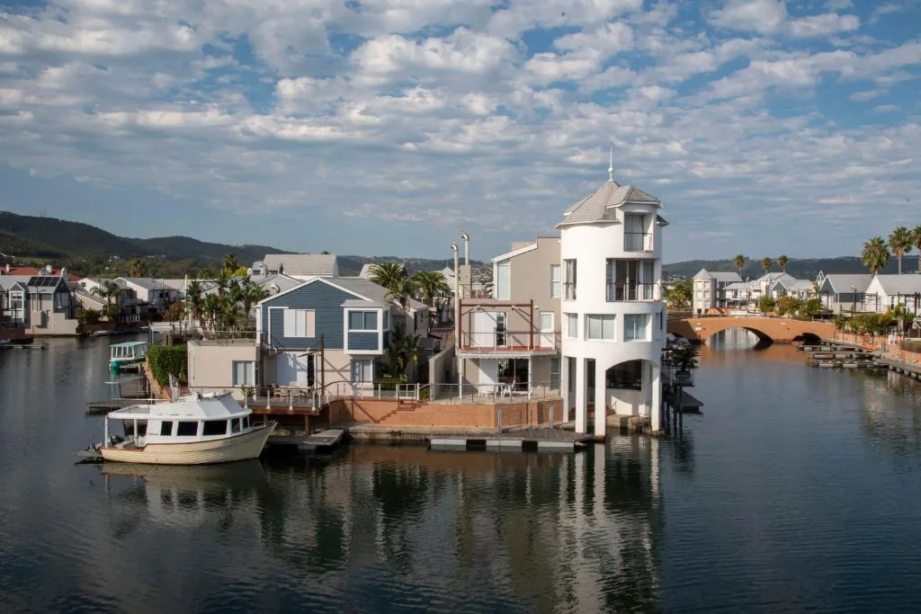 Waterfront property with distinctive white tower and boat dock on lagoon