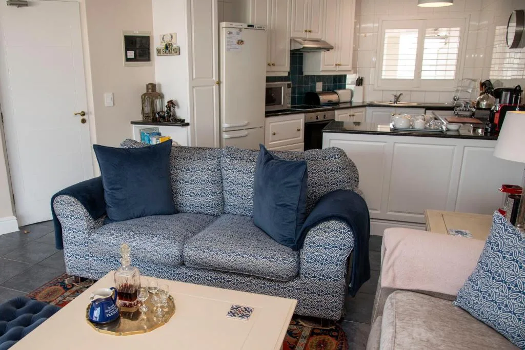 Open-plan lounge with patterned sofa, coffee table, and adjacent kitchen area