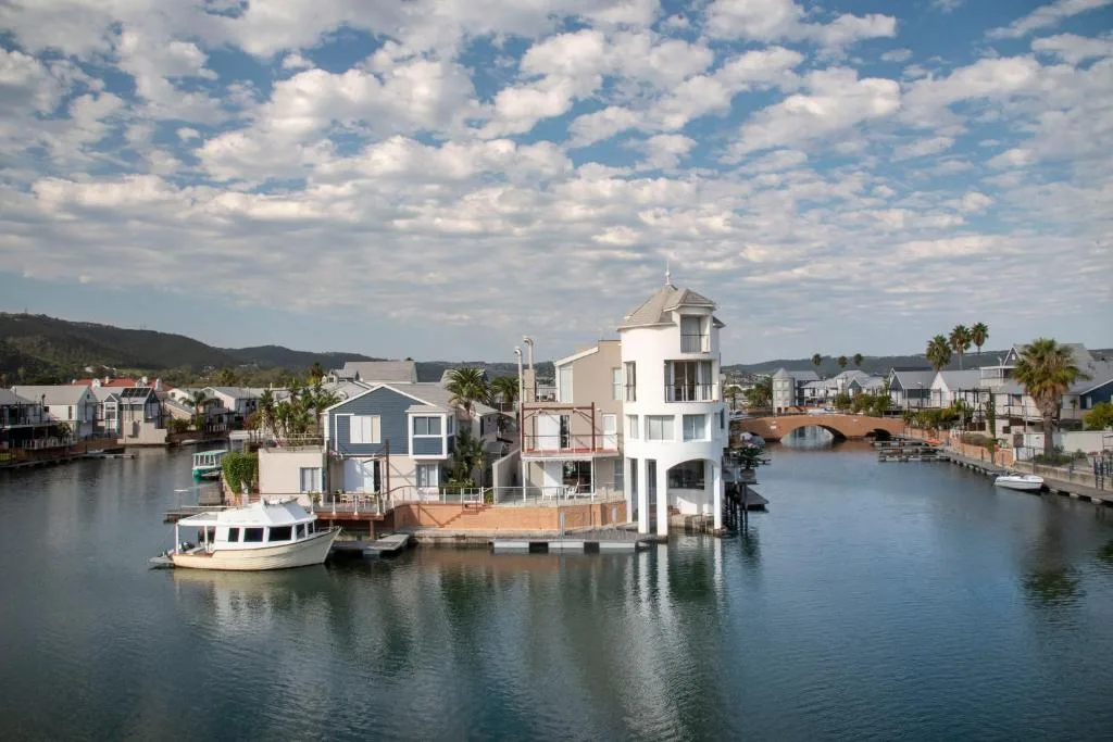 Waterfront property on Knysna Lagoon with boats and mountains beyond