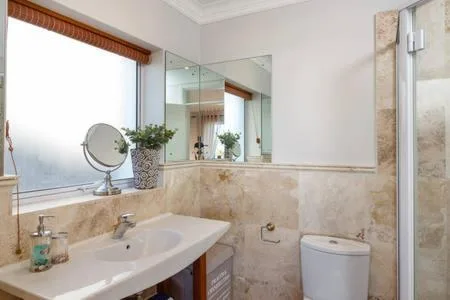 Bathroom with curved sink vanity, large mirror, and tiled shower enclosure