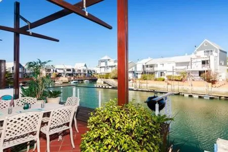 Waterfront patio with white chairs overlooking calm lagoon water